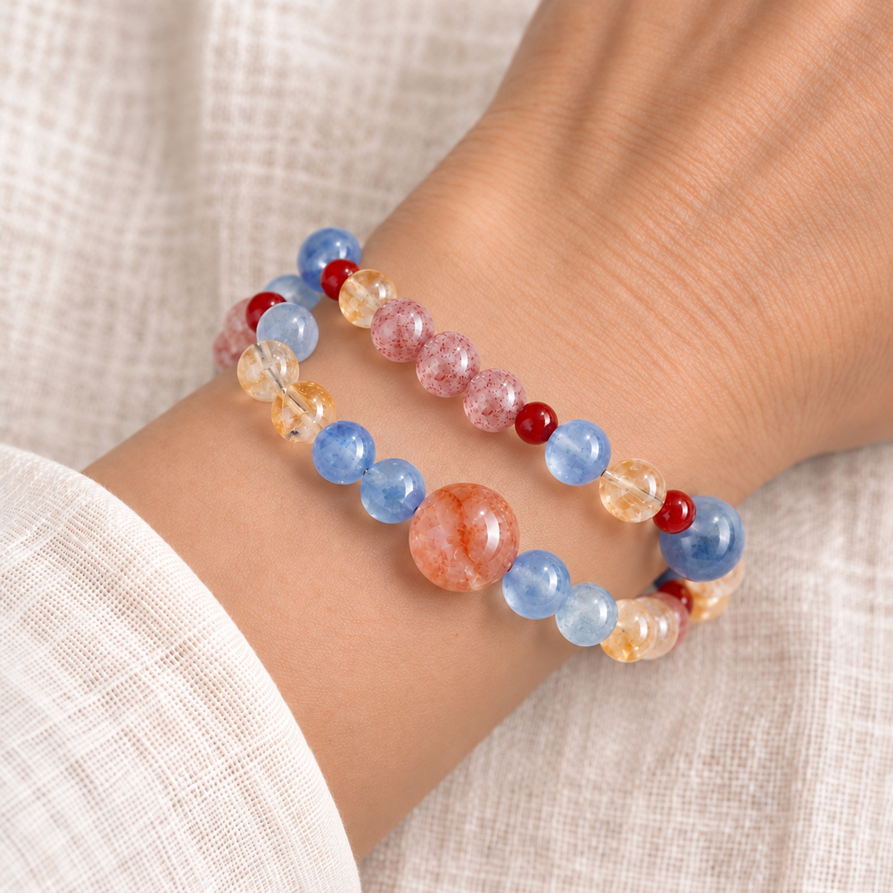 Chromara double-strand multicolor bead bracelet worn around the wrist, featuring a peach center bead, blue beads and a row of pink beads