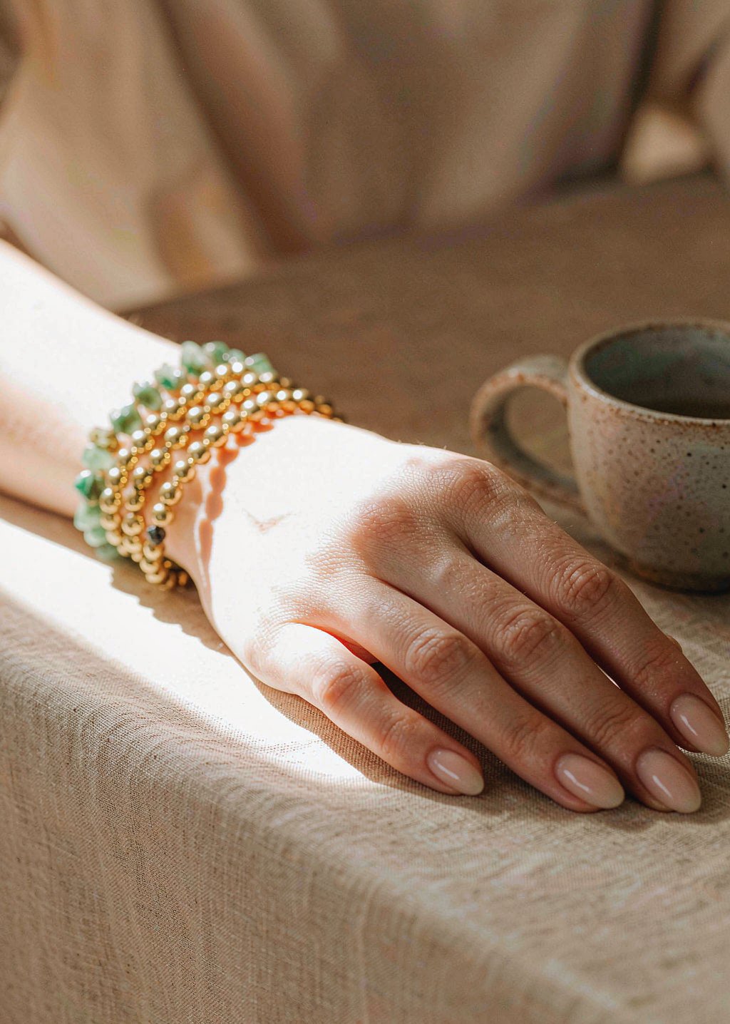 Pale-green bead bracelets on the wrist
