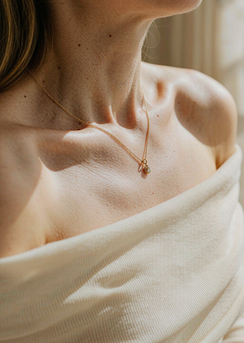Gold pendant necklace on the collarbone
