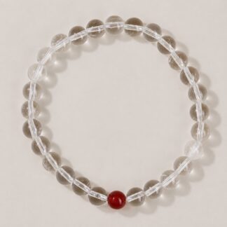 Single clear round-bead bracelet with ruby red focal accent, approximately 6 mm beads