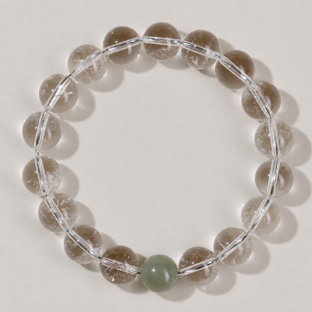Single clear round-bead bracelet with celadon green focal accent, approximately 10 mm beads