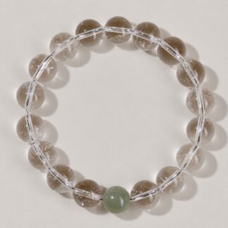 Single clear round-bead bracelet with celadon green focal accent, approximately 10 mm beads