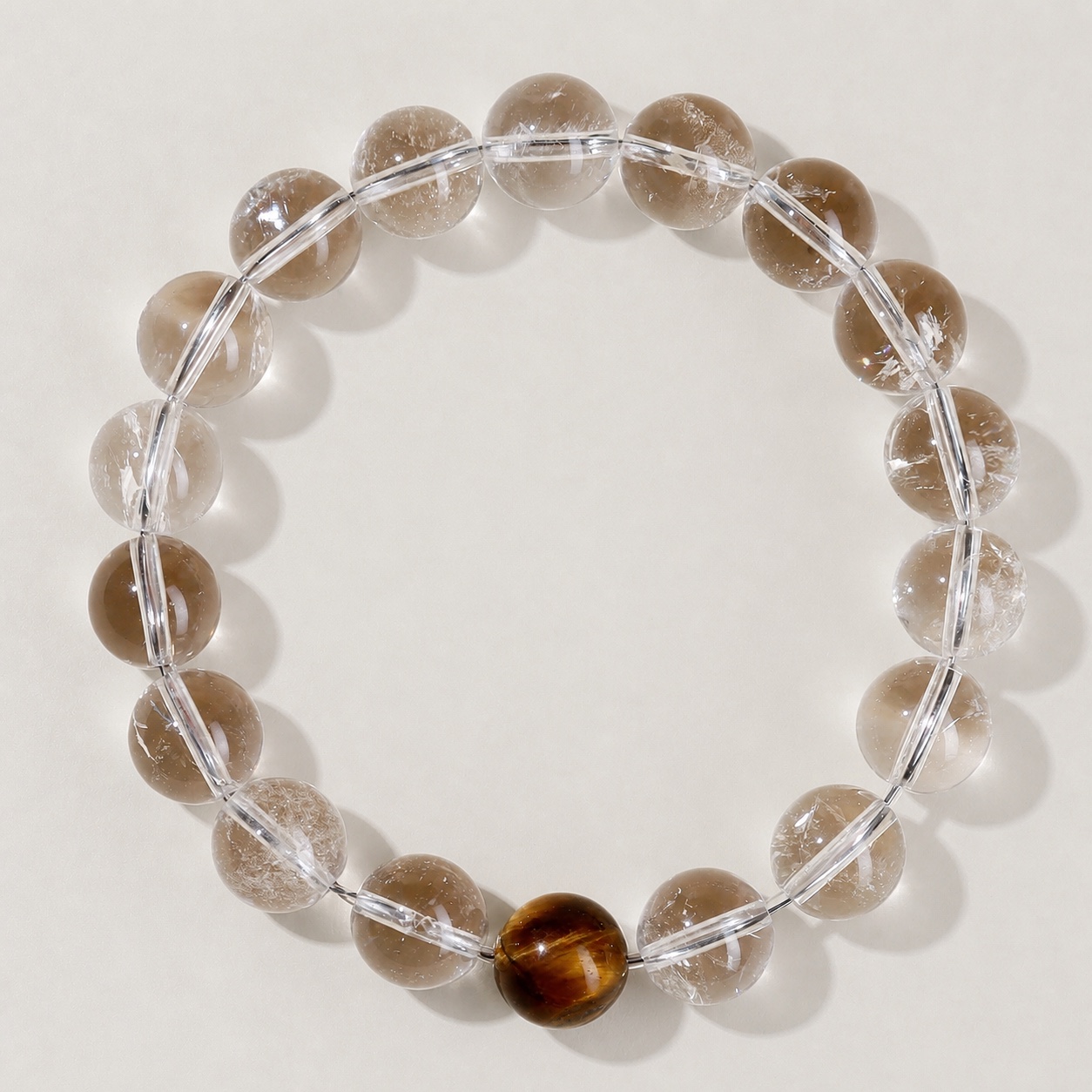 Single clear round-bead bracelet with tiger-eye brown focal accent, approximately 10 mm beads