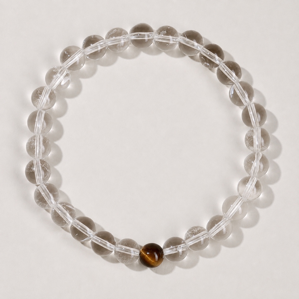 Single clear round-bead bracelet with tiger-eye brown focal accent, approximately 6 mm beads